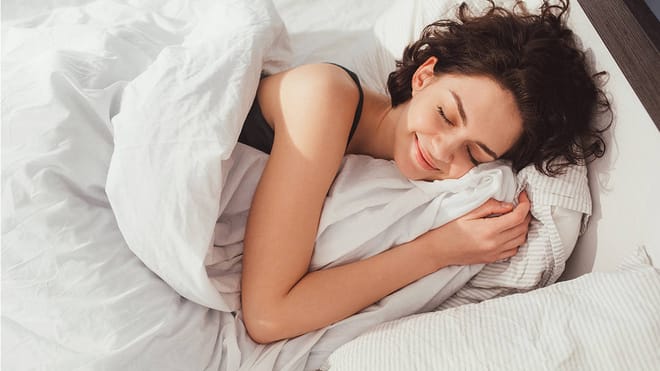 Une femme endormie et sereine, vetue d'un linge de lit blanc